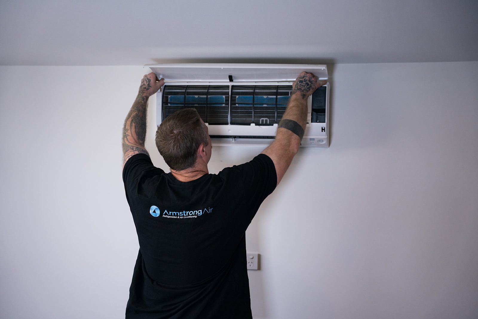Armstrong Air technician installing a split system head unit