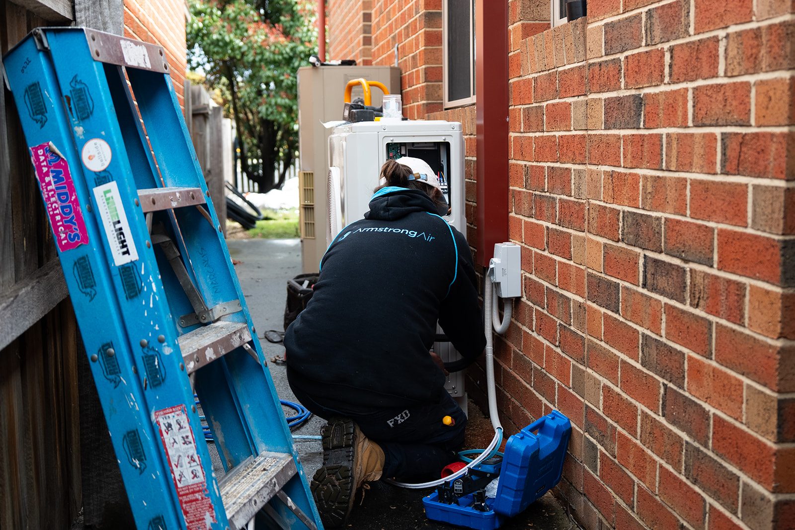 Armstrong Air technician servicing an outdoor unit